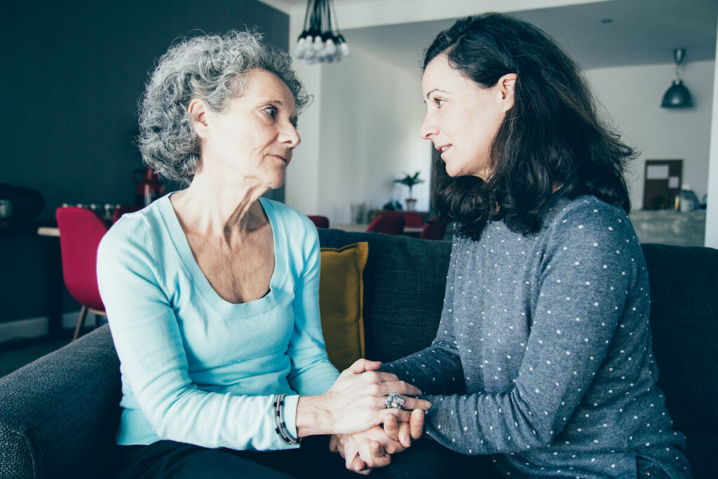 Adult daughter talking to mother at home