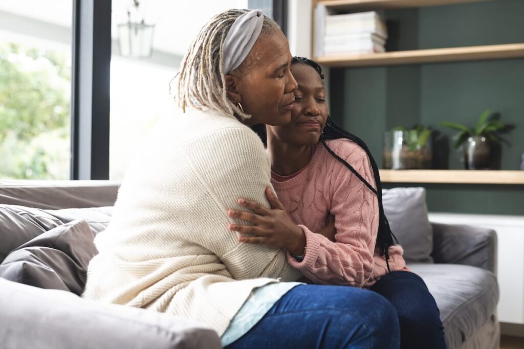 Adult daughter hugging her mother at home