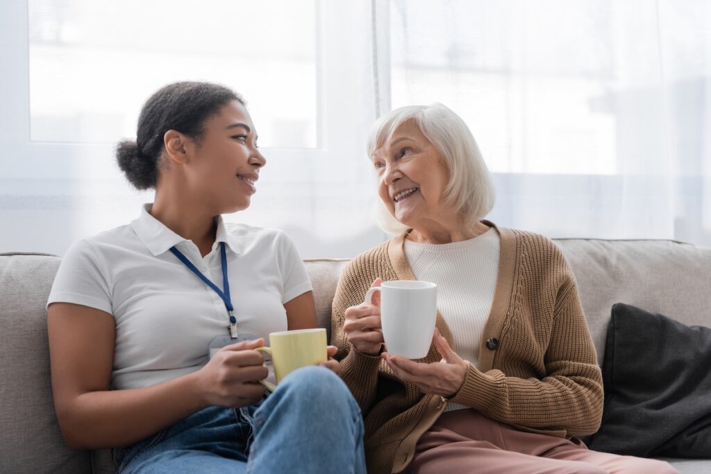 Smiling caregiver having a conversation with an older woman