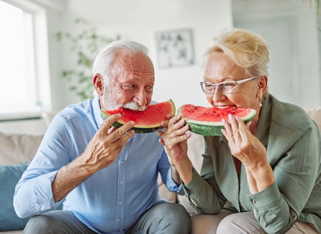 Senior Couple Eating Watermelon on Couch