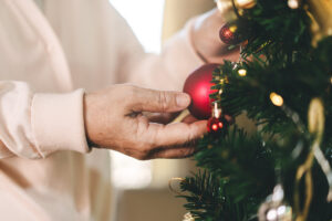 Older person decorating a Christmas tree