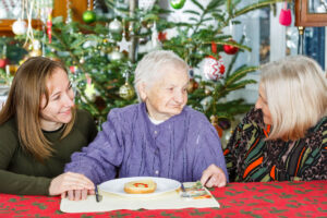 Adult daughters celebrating the holidays with mom in memory care